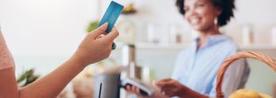 a woman holding a credit card in a kitchen.