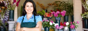 a woman standing in front of a flower shop.