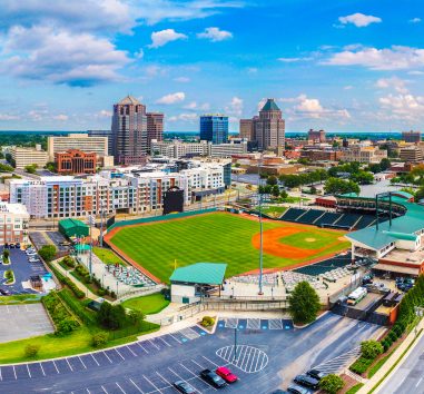 Image of downtown Greensboro, including buildings and baseball field.